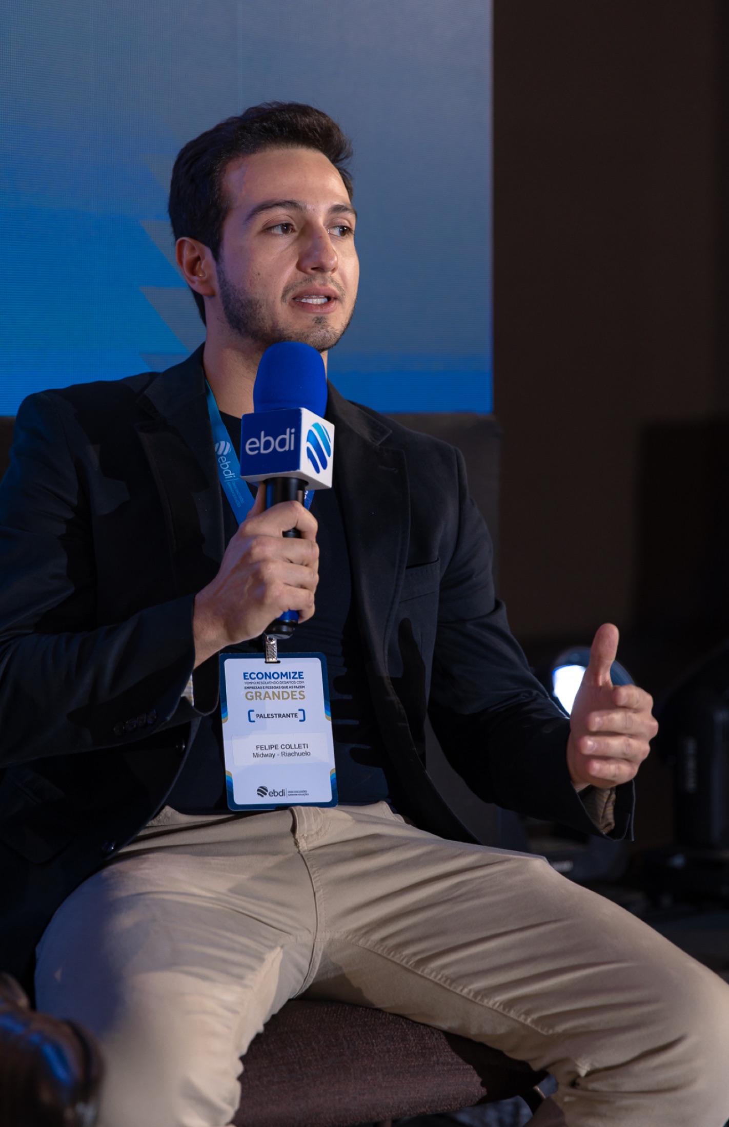 Felipe presenting to an audience with a microphone